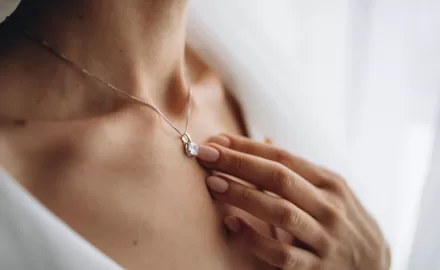 mulher usando colar delicado com pingente de pedra, representando cuidados e conservação de joias